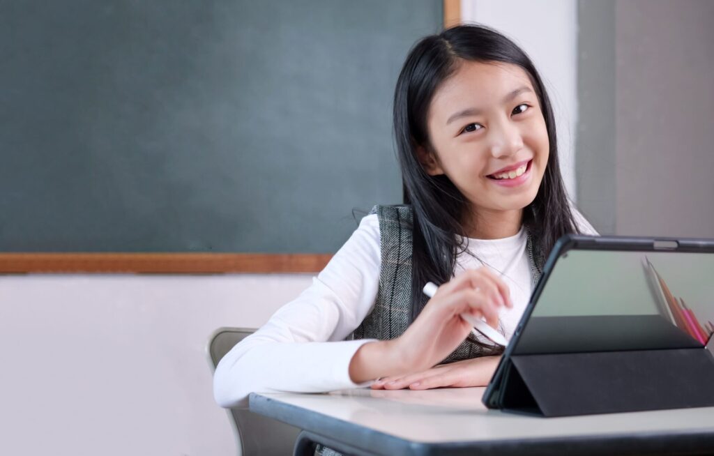 Smiling student studying with IELTS One-to-One Coaching at ILC Training, focused on improving exam skills.