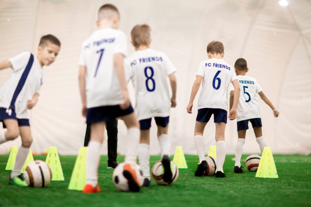 Young football players in matching kits walking on the field during training session in Hua Hin English Football Course.