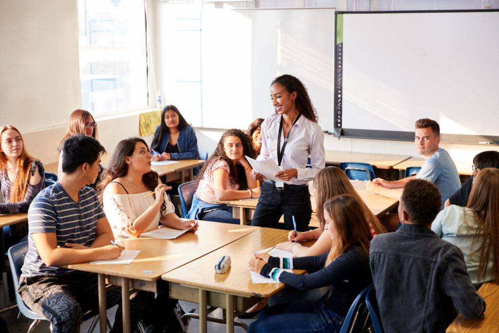 Teenagers participating in a Trinity GESE Intermediate Stage English class with group discussion.