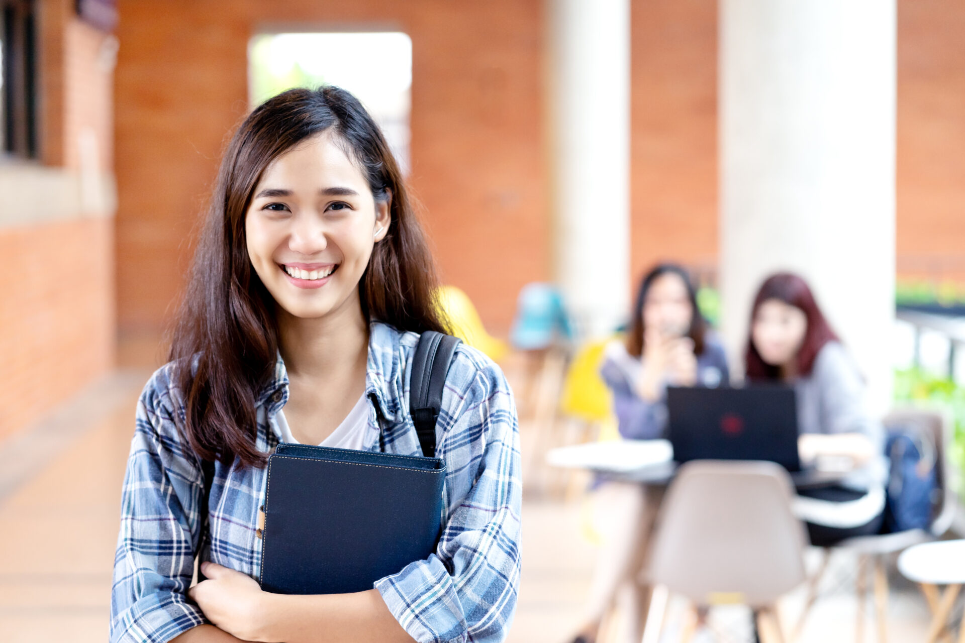 LC Hua Hin student smiling on campus holding study materials