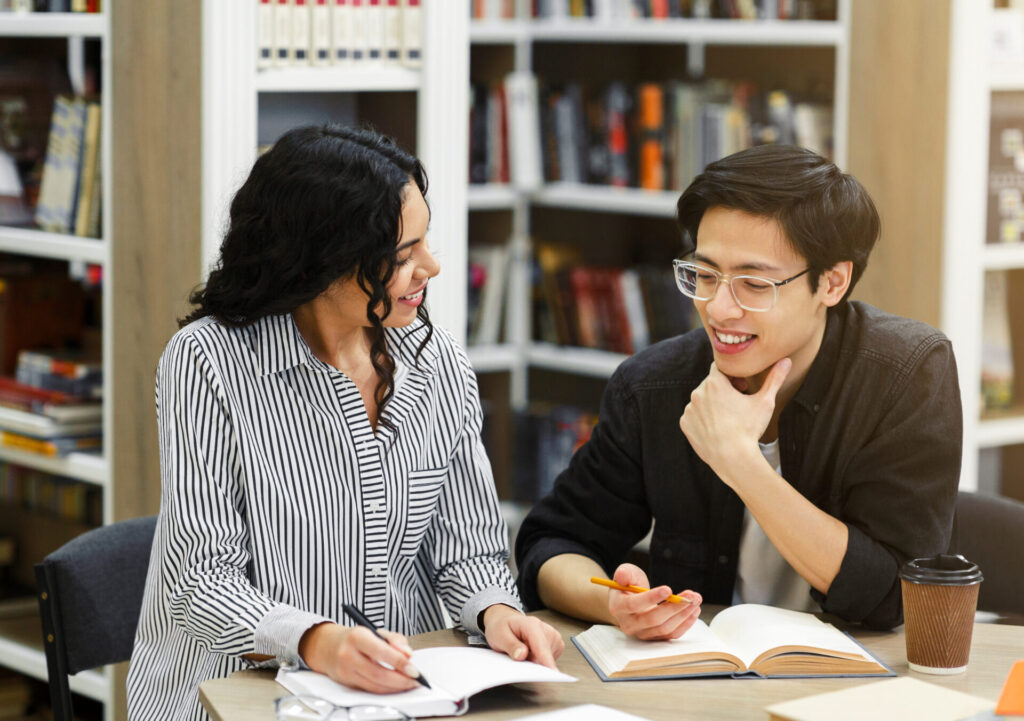 ILC Blog - Two students studying together in a library for an English learning blog post.