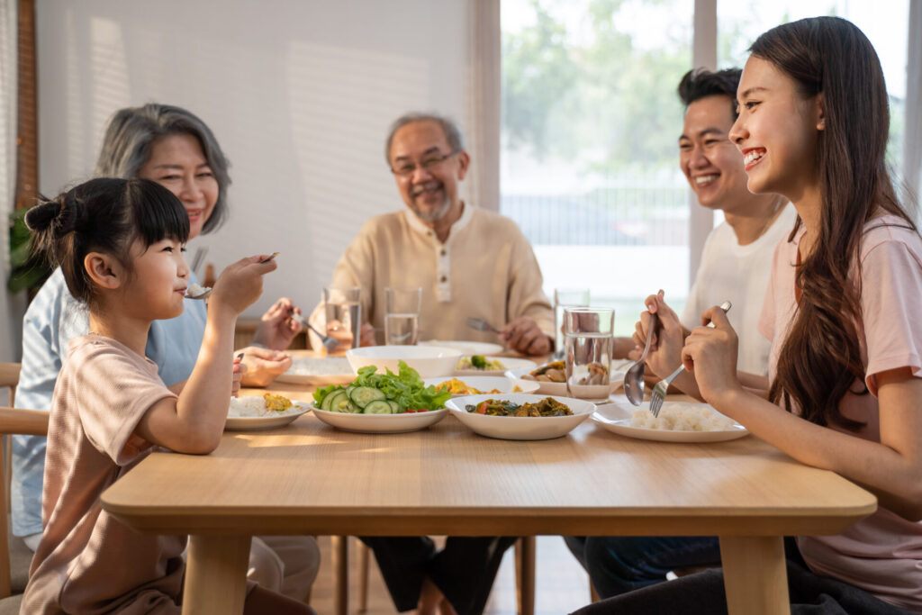 IELTS Family and Relationships in Thailand 2025 – three generations of a Thai family eating dinner together at home.