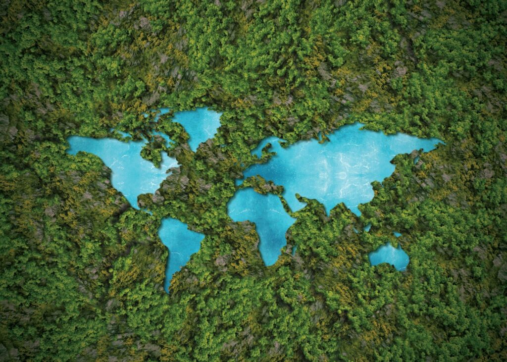 World map made of green forest and blue water, symbolising sustainability and IELTS Energy and Environment themes.