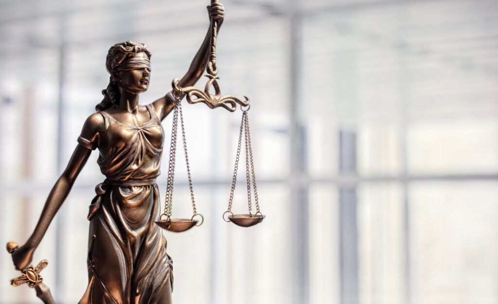 Lady Justice statue holding scales, symbol of law, fairness, and punishment, used for IELTS Crime and Punishment theme.