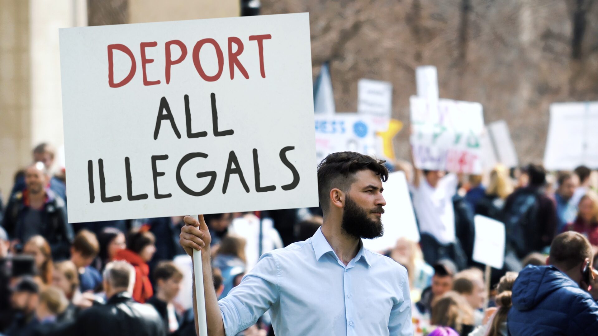 IELTS Migration and Immigration 2025 – protest with sign about immigration policies
