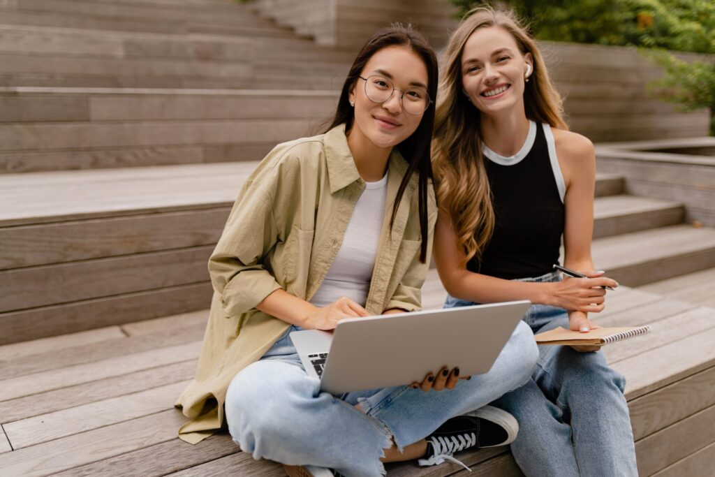 IELTS Globalisation and Culture 2025 3 Two international students studying together outdoors, preparing for IELTS Globalisation and Culture topics.