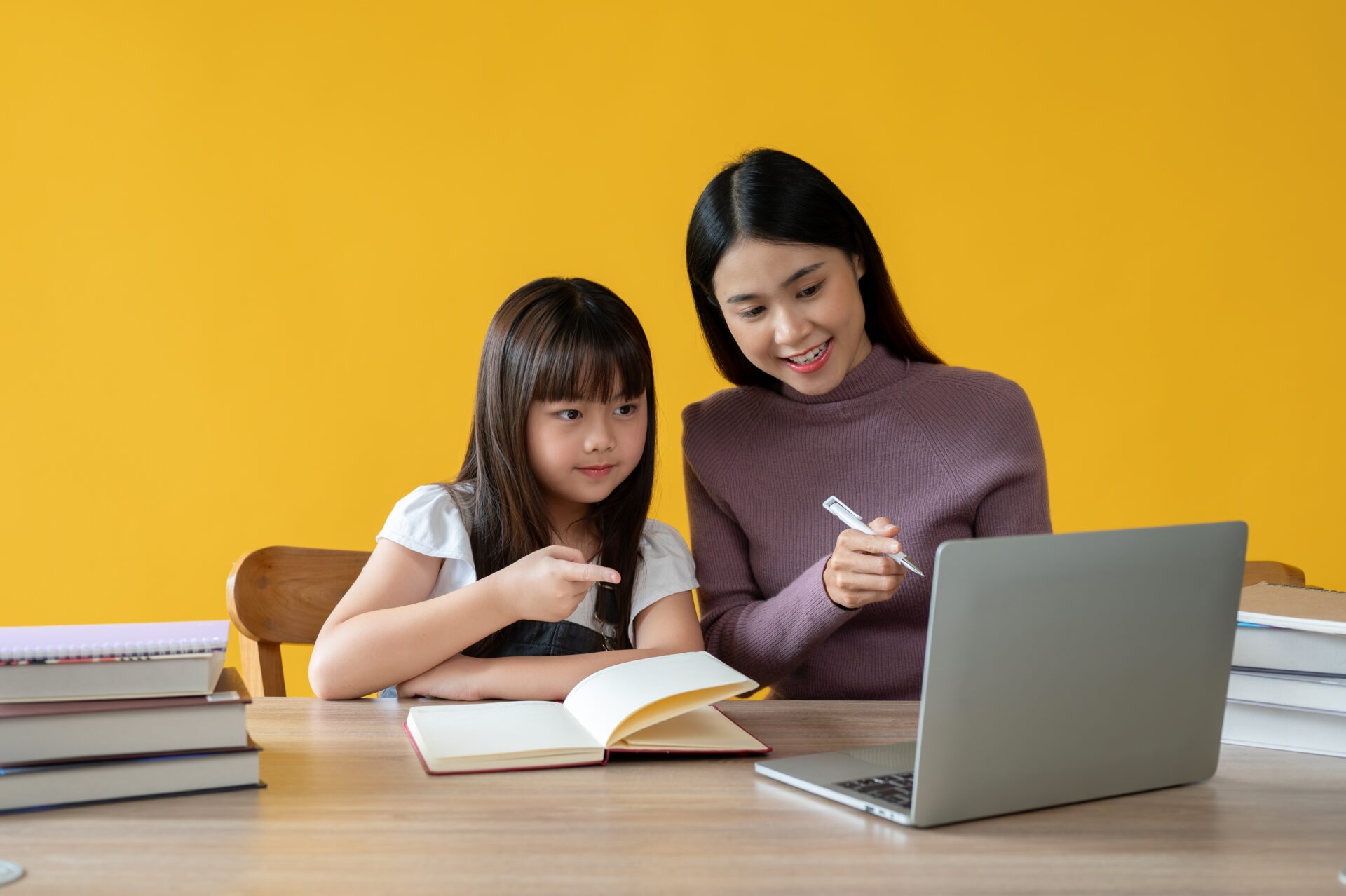 Teacher and young student studying together in during an English course at ILC Hua Hin, focusing on listening and speaking practice.