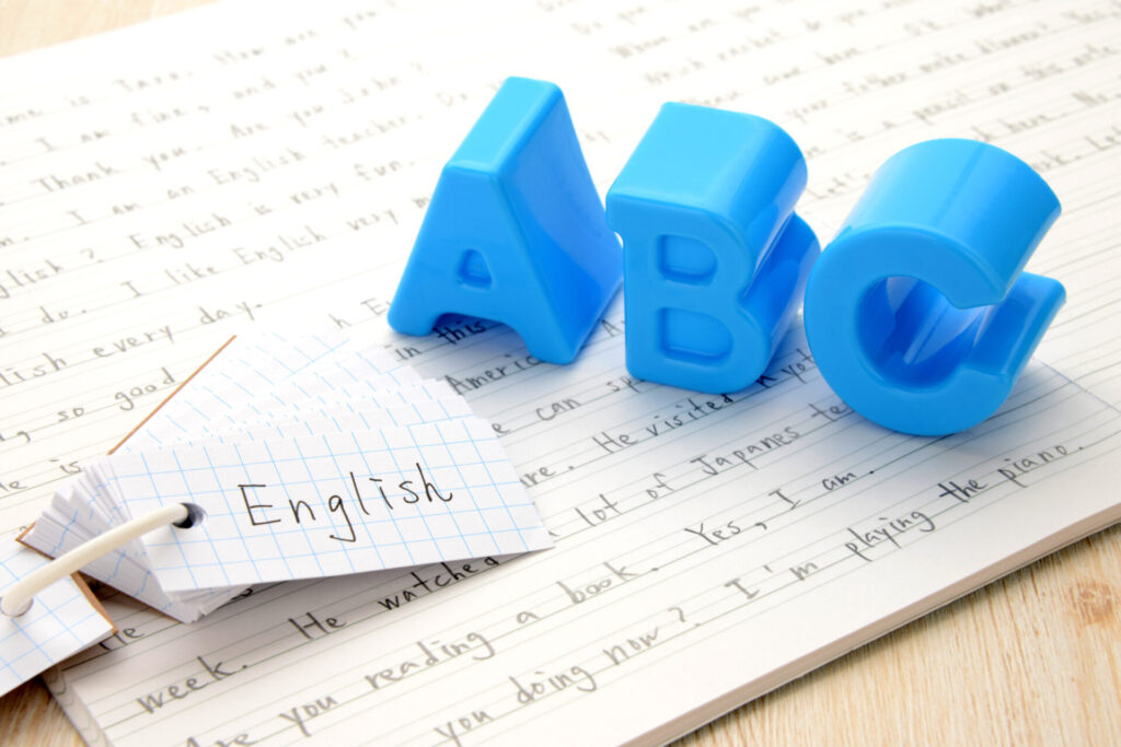 English study concept with blue A B C letters and vocabulary cards on notebook, representing beginner Conversation English learning at ILC Hua Hin.