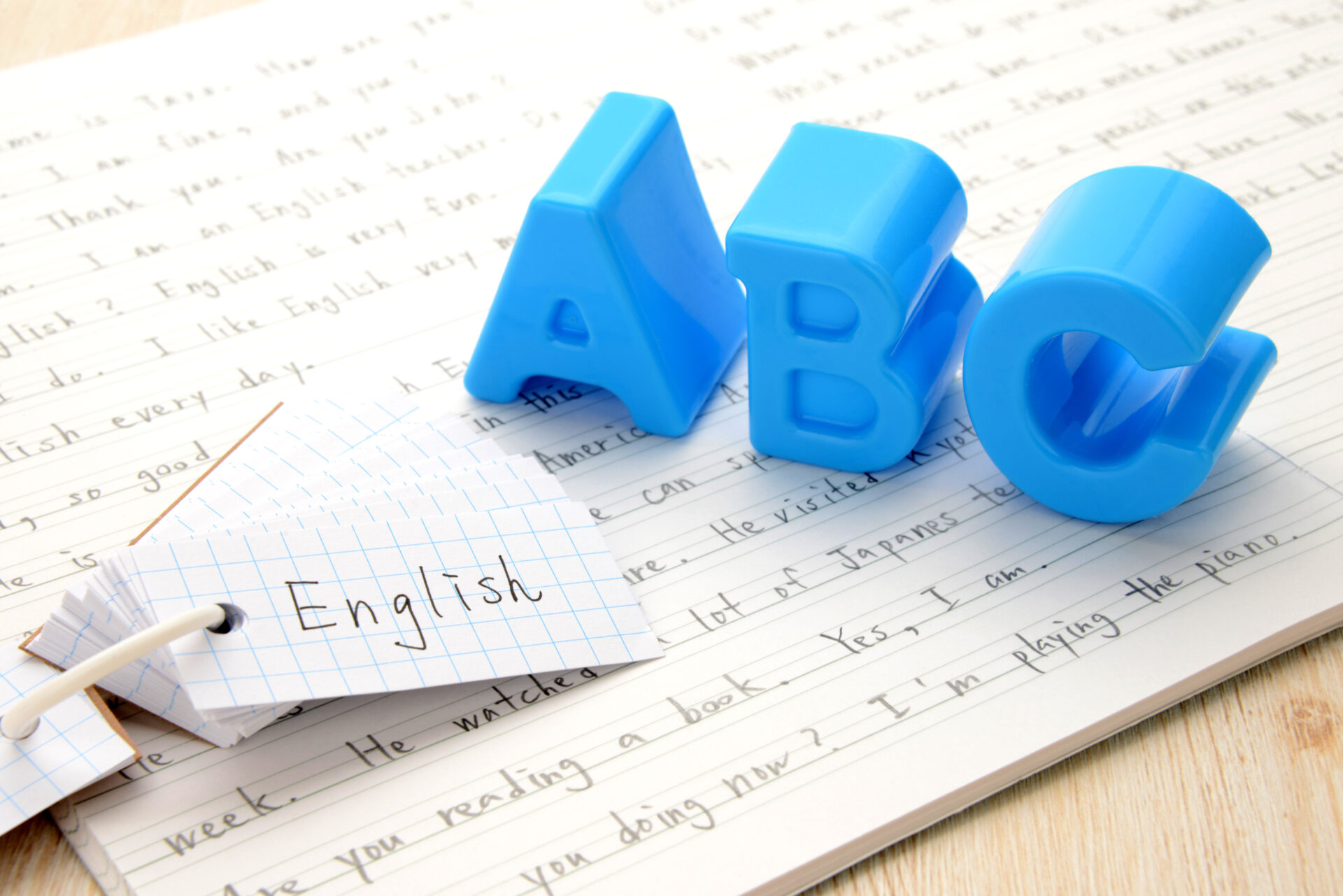 English study concept with blue A B C letters and vocabulary cards on notebook, representing beginner Conversation English learning at ILC Hua Hin.