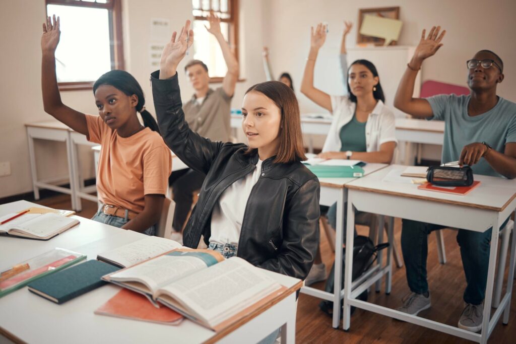 Study for IELTS in Hua Hin students raising their hands in an active classroom at ILC Hua Hin.