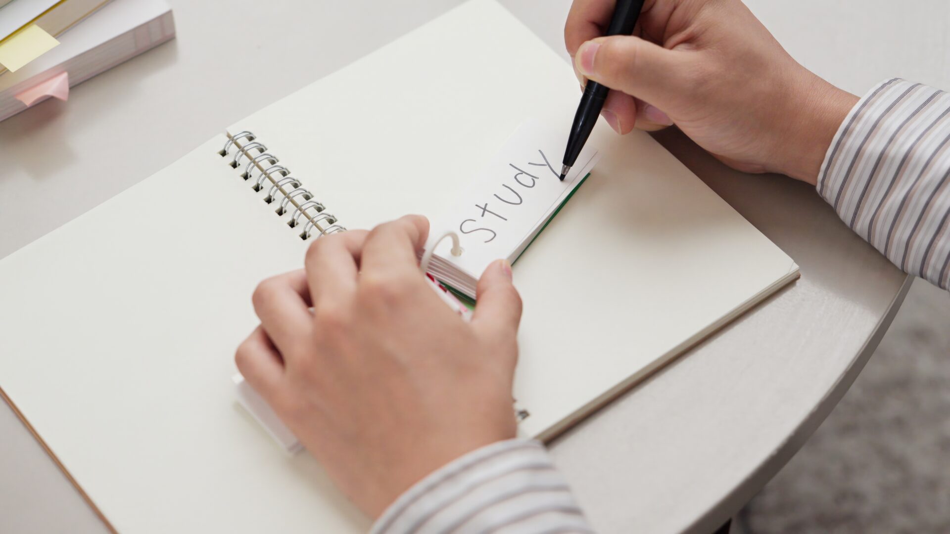 Close-up of a learner writing vocabulary flashcards while studying for adult english classes at ILC Hua Hin.